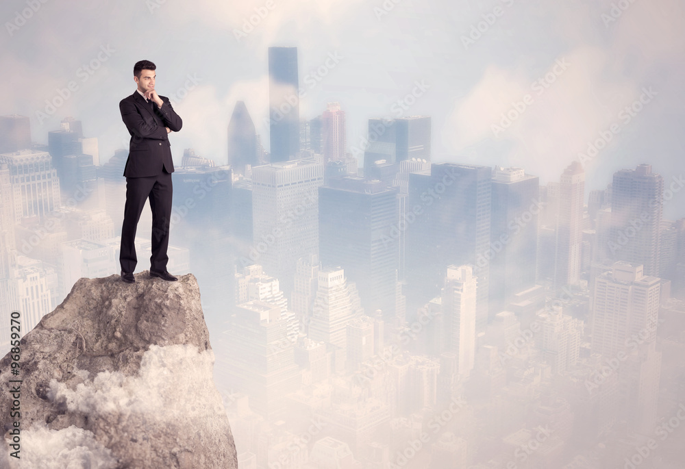 Winner urban businessman on top of stone Winner urban businessman on top of stone