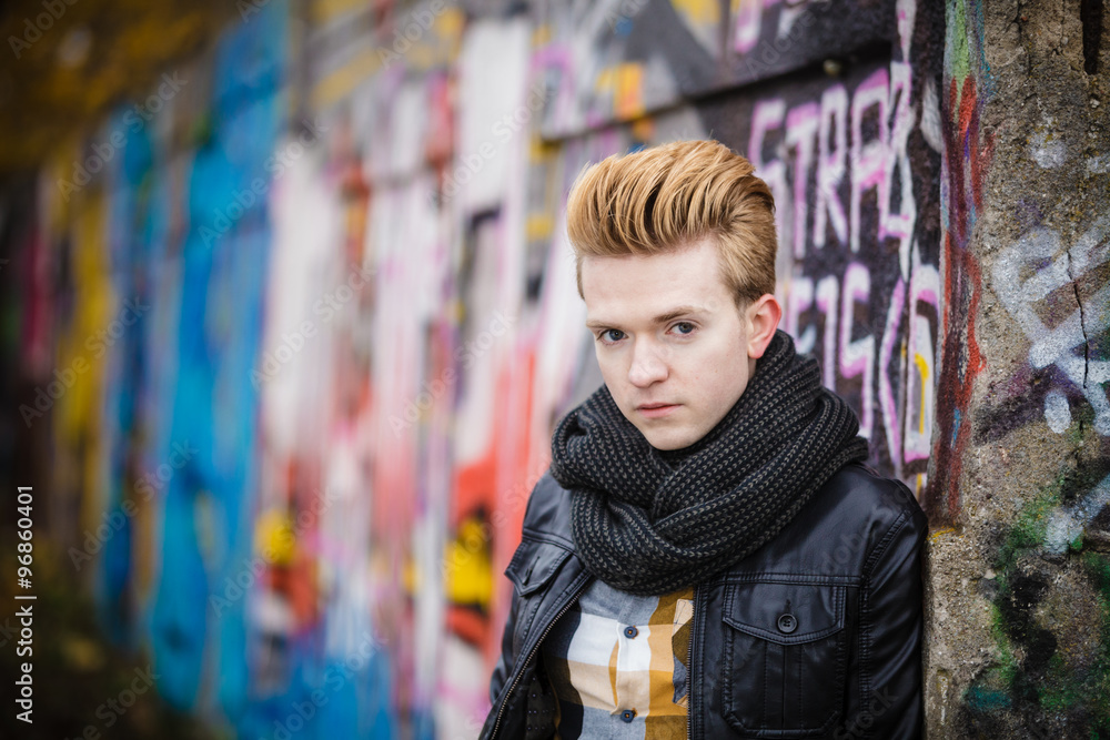 Naklejka premium Fashion male portrait on graffiti wall