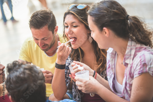 Tourists eating slush, talking and looking each other