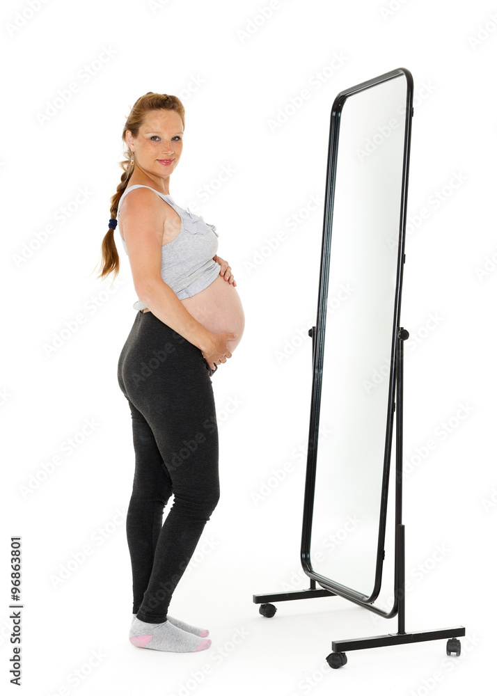 Pregnant woman stands before mirror. Pregnant woman stands before mirror.
