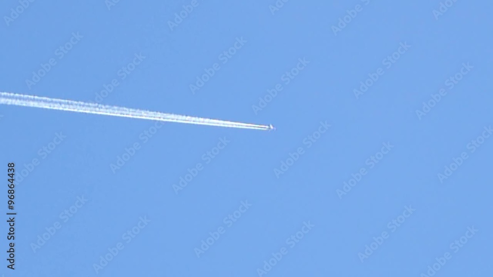 sunlit jet crossing the blue sky downward (slow motion) sunlit jet crossing the blue sky downward (slow motion)
