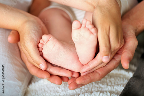Adult hands holding baby feet, closeup © Africa Studio
