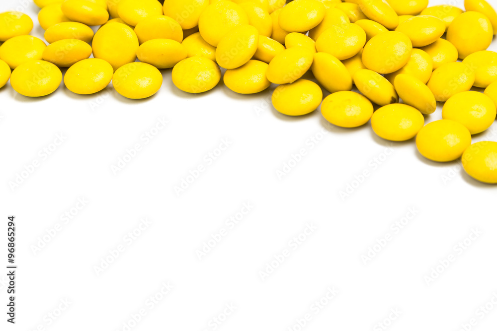 Top right frame of yellow chocolate candy on white background Top right frame of yellow chocolate candy on white background