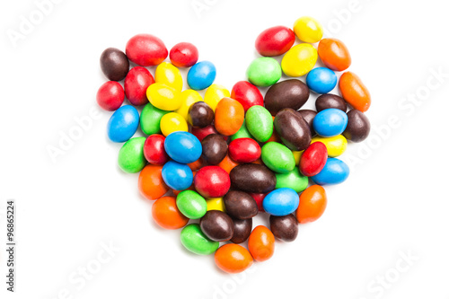 Heart shape with colorful milk chocolate candies on white backgr