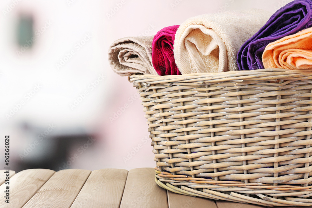 Obraz premium Colorful towels in basket on bright background