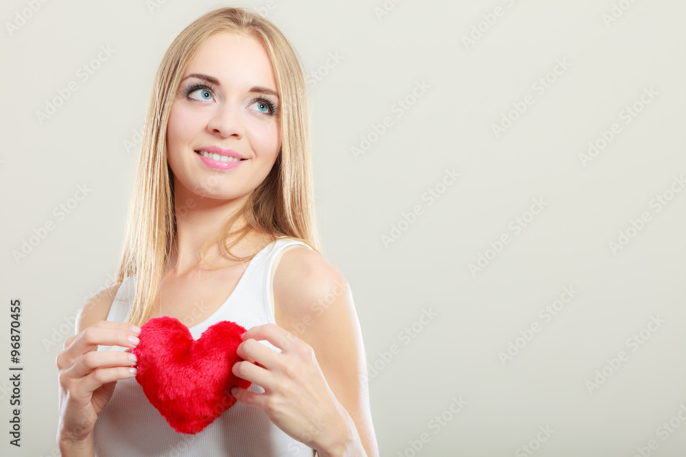 Smiling woman holding red heart love symbol Smiling woman holding red heart love symbol