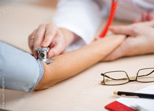 Doctor measuring blood pressure of patient