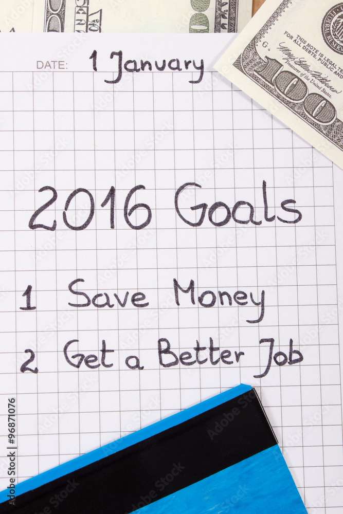 New years resolutions written in notebook, currencies dollar and credit card New years resolutions written in notebook, currencies dollar and credit card