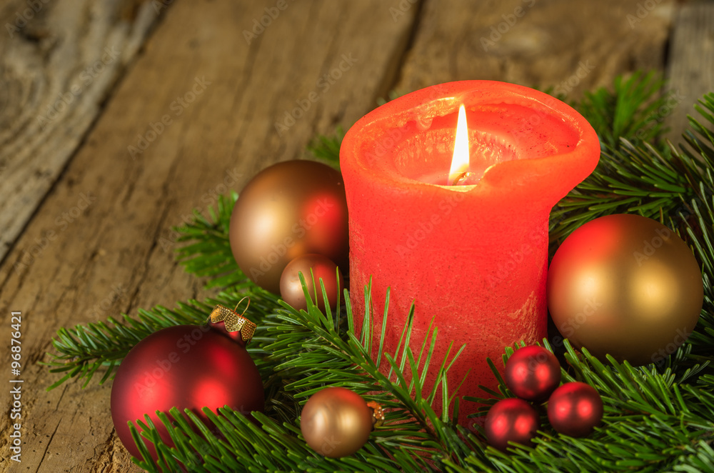 Burning candle at festive christmas arrangement Burning candle at festive christmas arrangement