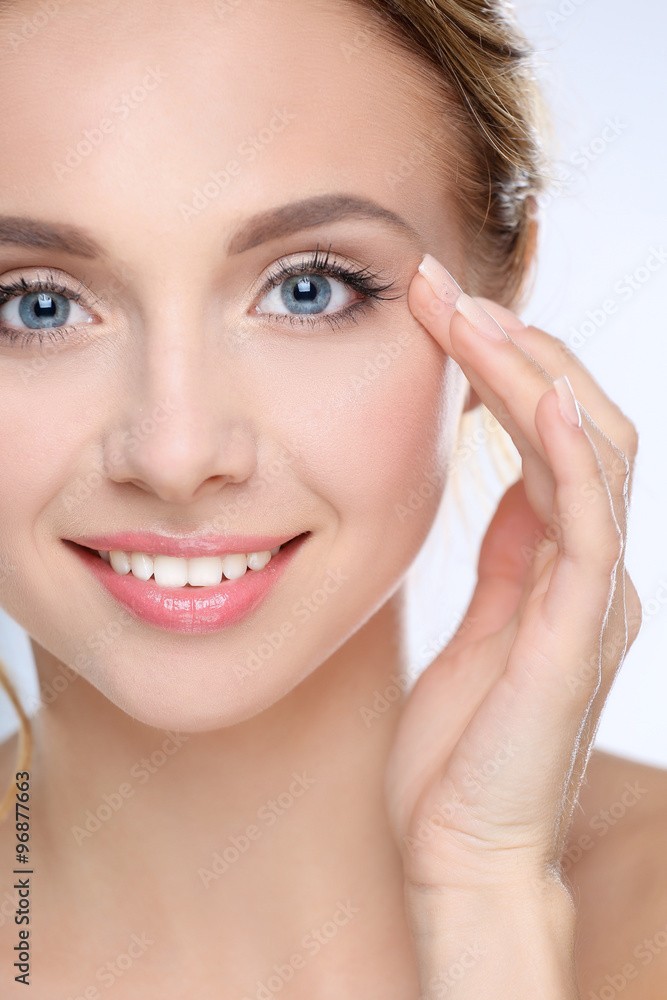 Fototapeta premium Young woman touching her face isolated on white background