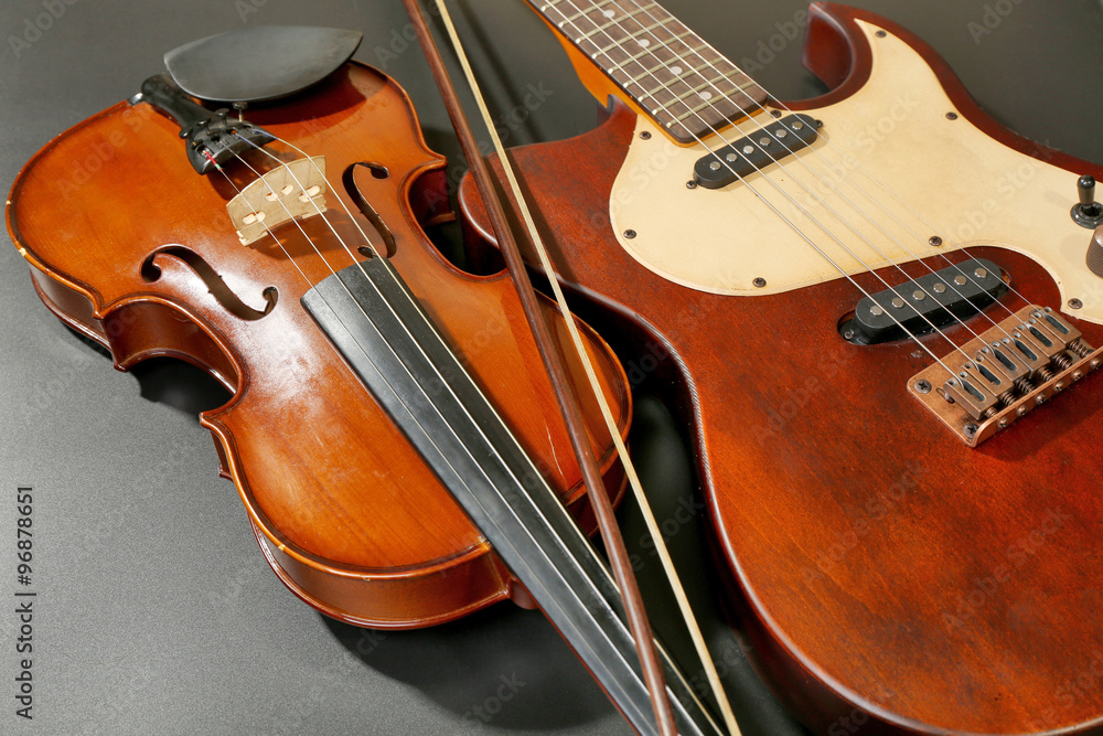 Electric guitar and violin on grey background Electric guitar and violin on grey background