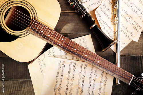Tableau sur toile Acoustic guitar, soprano saxophone, violin, flute and note sheets on wooden back