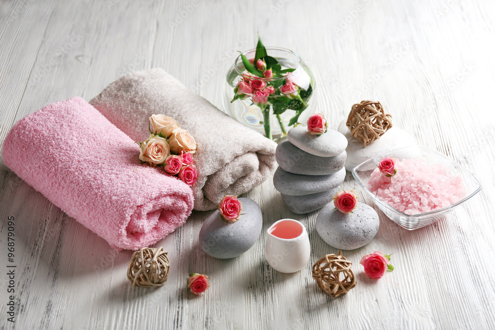 Composition of flowers, salt and stones on white wooden background, in spa salon Composition of flowers, salt and stones on white wooden background, in spa salon