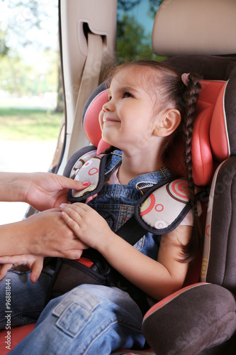 Cute little girl sitting in...