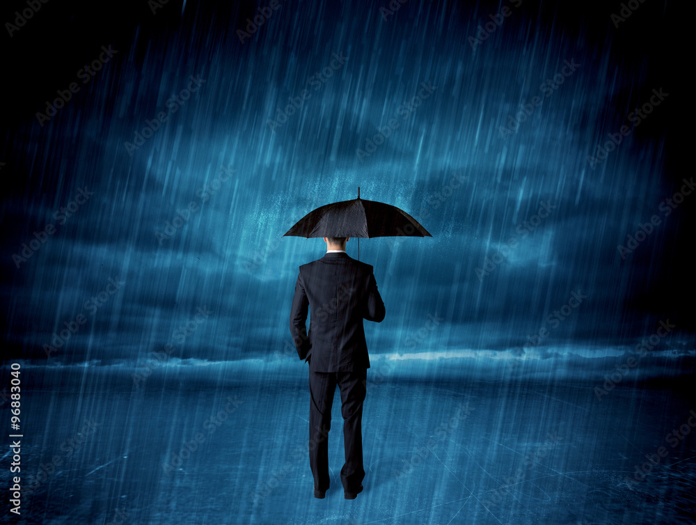 Business man standing in rain with an umbrella Business man standing in rain with an umbrella