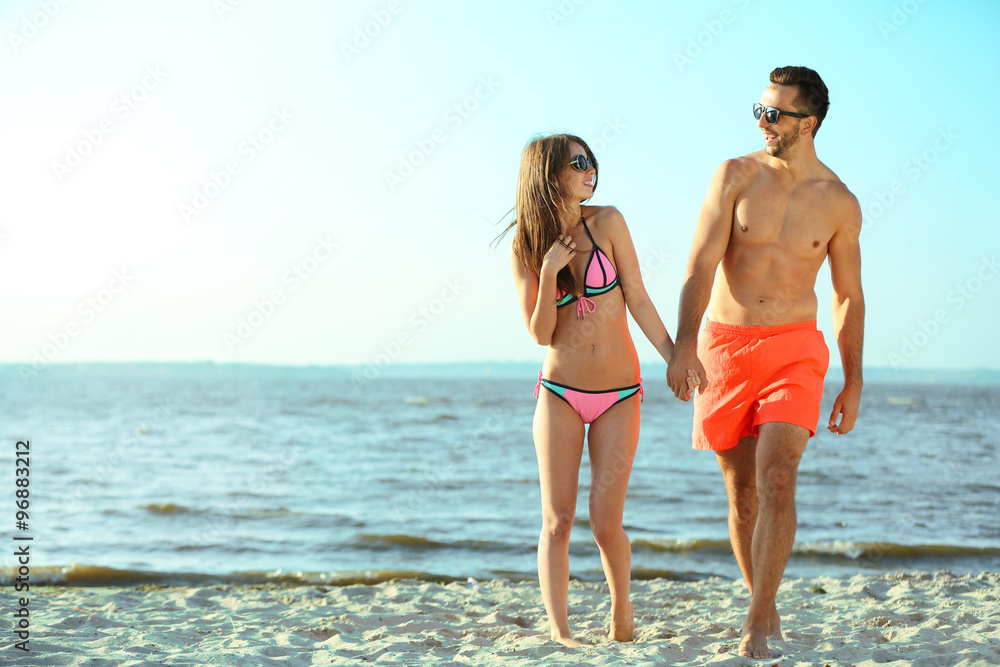 A happy couple holding hands at the beach, outdoors A happy couple holding hands at the beach, outdoors