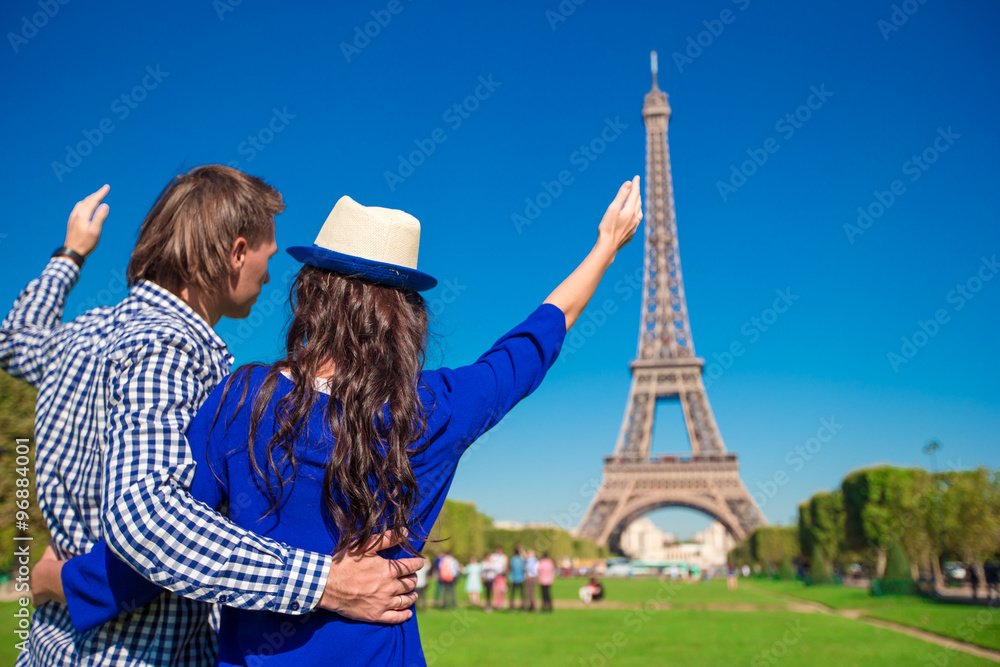 Young happy couple on the Champ de Mars in Paris background the Eiffel Tower