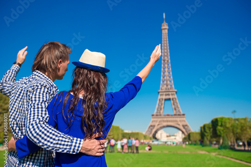 Young happy couple on the Champ de Mars in Paris background the Eiffel Tower © travnikovstudio