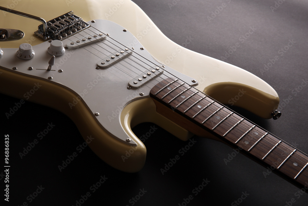 Part of white electric guitar, on black background Part of white electric guitar, on black background