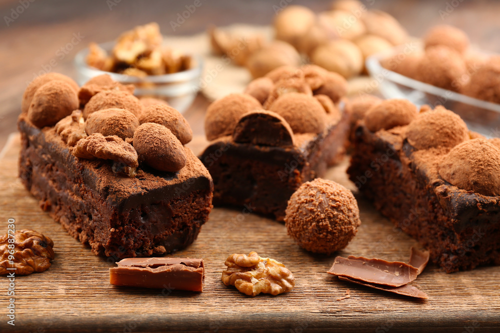 Fototapeta premium Pieces of chocolate cake with walnut on the table, close-up