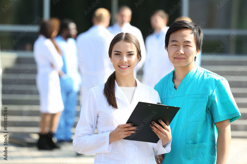 Medical concept - two doctors with stethoscopes and prescription clipboard Medical concept - two doctors with stethoscopes and prescription clipboard