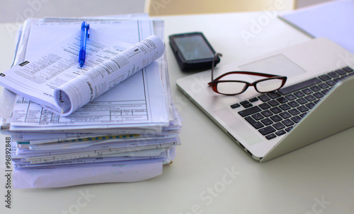 Office table with blank notepad and laptop 