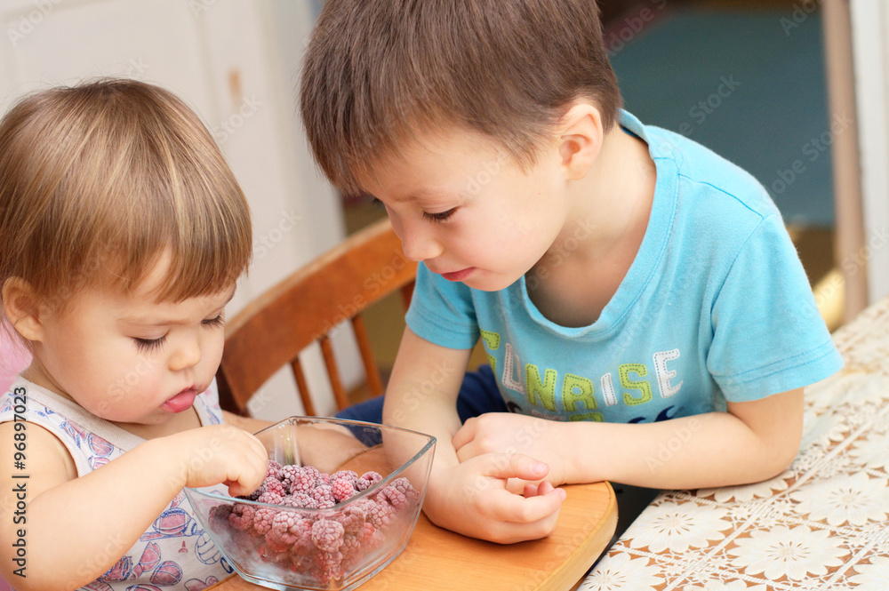children eating quick-frozen raspberries children eating quick-frozen raspberries