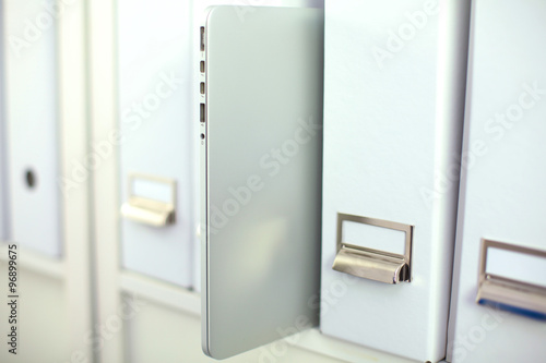 File folders  standing on  shelves in the background