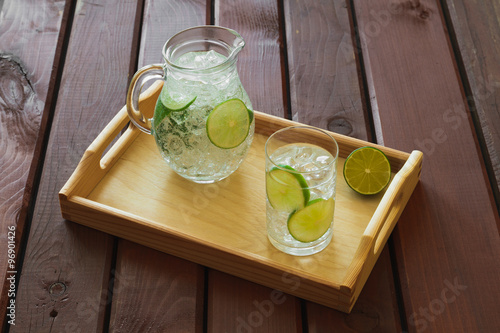 Obraz na płótnie Drink and jug on wooden tray with ice and condensation on glass w salonie