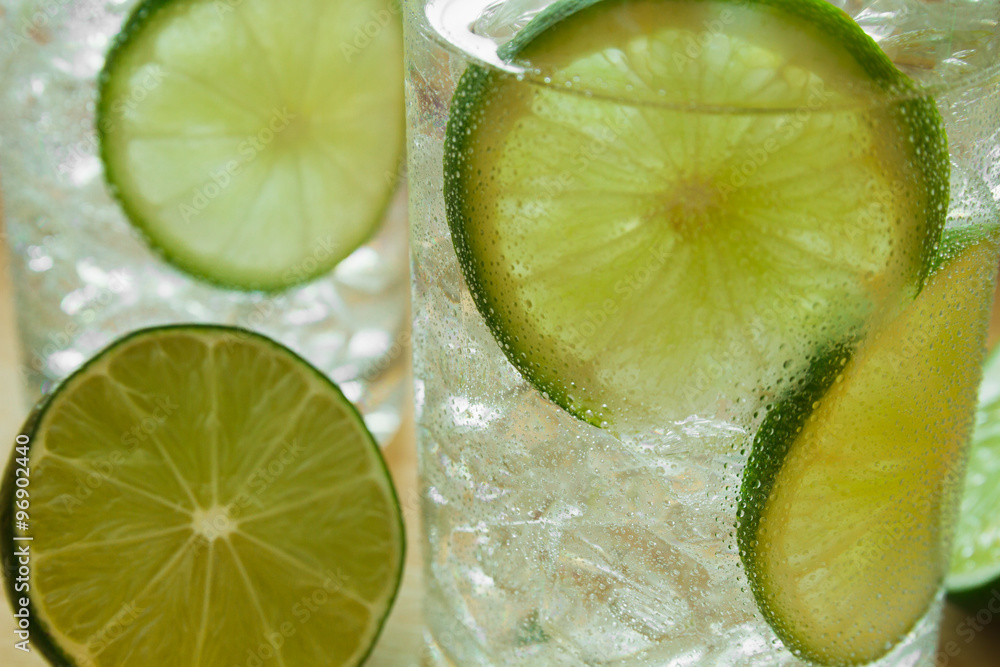 Two drinks on wooden tray with ice and condensation on glass