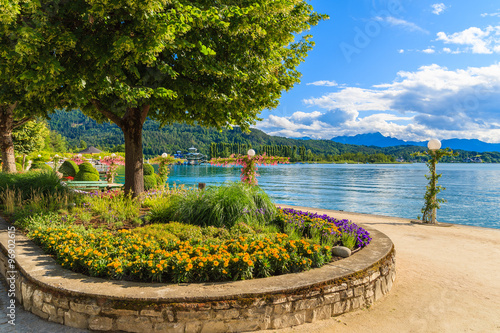 Promenade with flowers along Worthersee lake on beautiful summer day, Austria