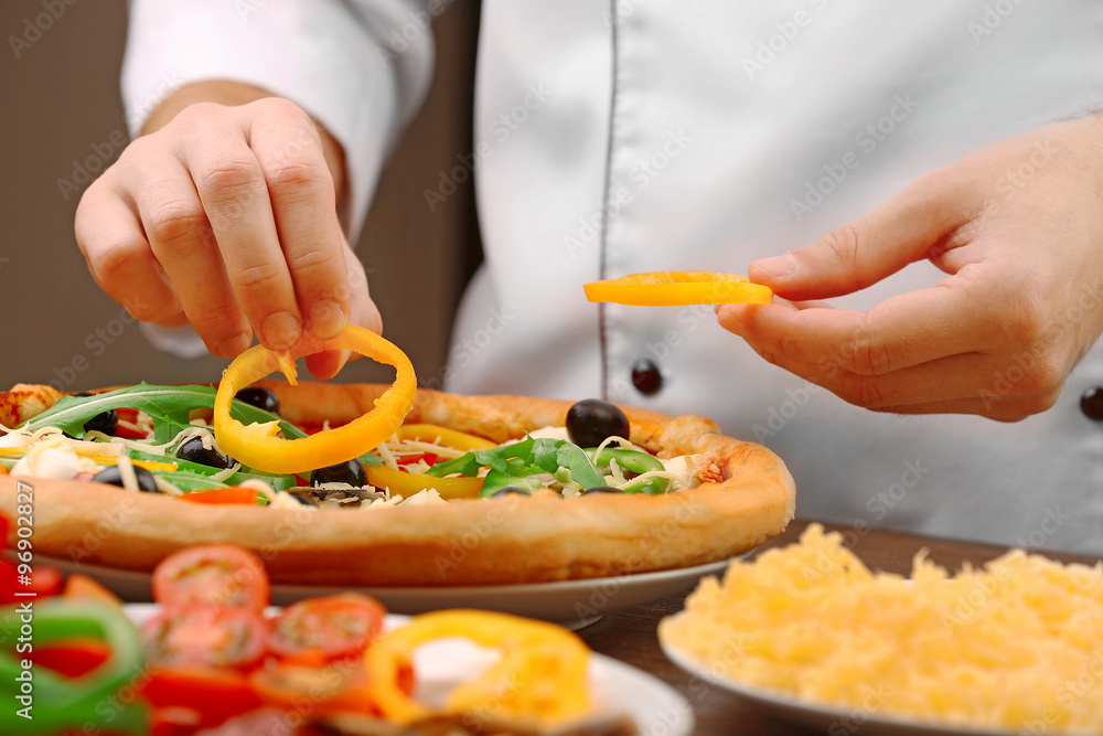 Cook making delicious pizza at the restaurant, close-up Cook making delicious pizza at the restaurant, close-up