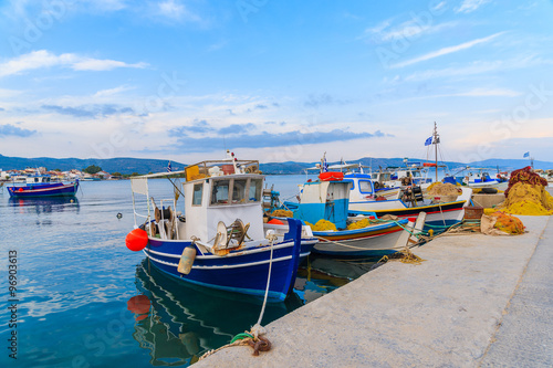 Colourful Greek fishing boats mooring in port at sunset time on Samos island, Greece