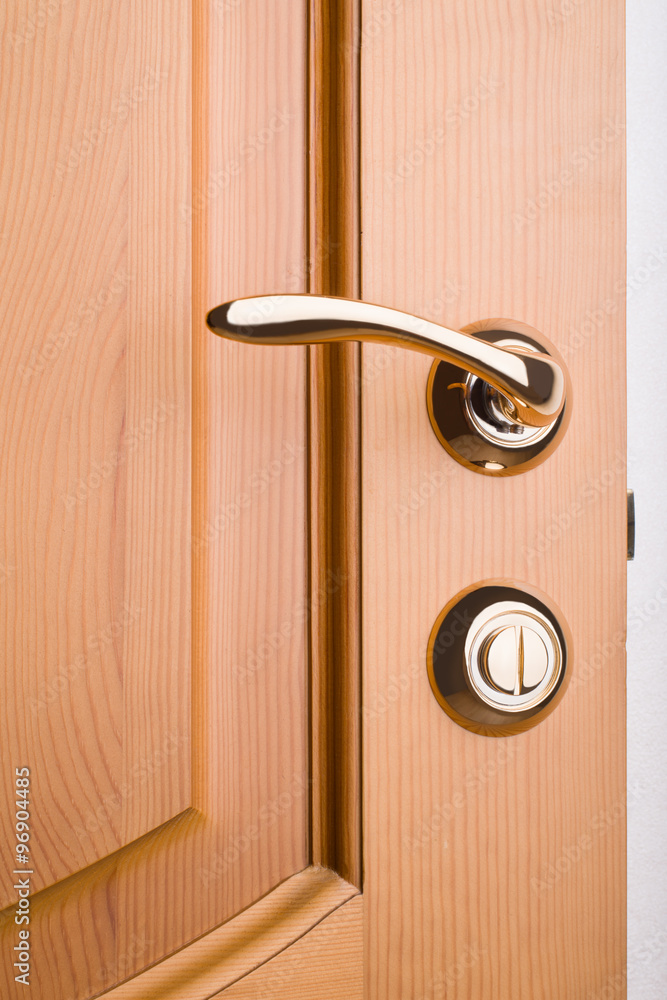 Closeup of a metal handle on wooden door Closeup of a metal handle on wooden door
