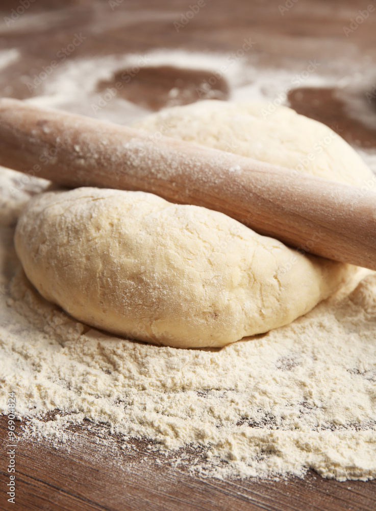 Dough for pizza and rolling-pin on wooden table Dough for pizza and rolling-pin on wooden table