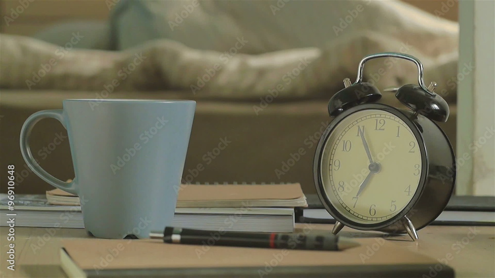 Man waking up by alarm clock at 7 o'clock in the morning.and he writing for unfinished work. Man waking up by alarm clock at 7 o'clock in the morning.and he writing for unfinished work.