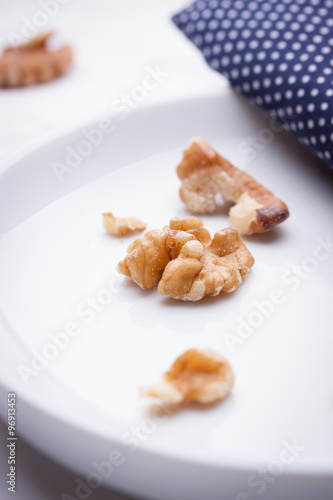 Walnuts on a white ceramic plate with blue napkin