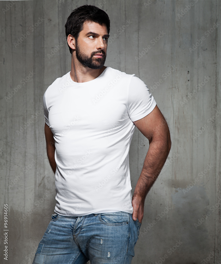 Portrait of a handsome man in a white T-shirt in the interior of the loft Portrait of a handsome man in a white T-shirt in the interior of the loft