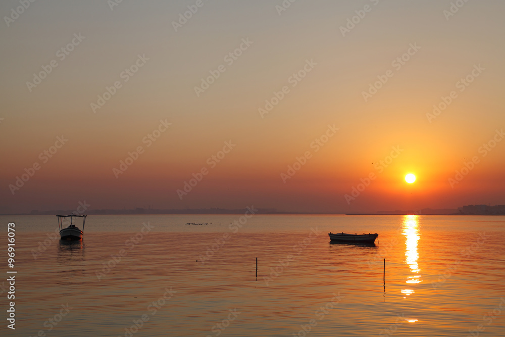 Boats and dramatic sunrise at Busaiteen beach