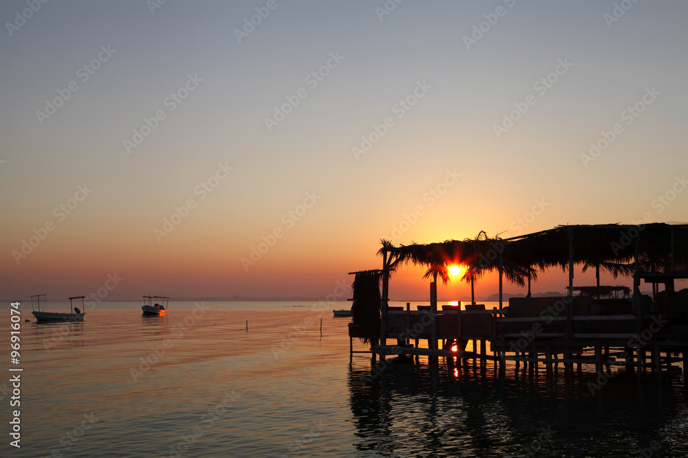 Silhouette of extended platform and sunrise at  Busaiteen beach