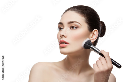 Beautiful girl applying powder with brush