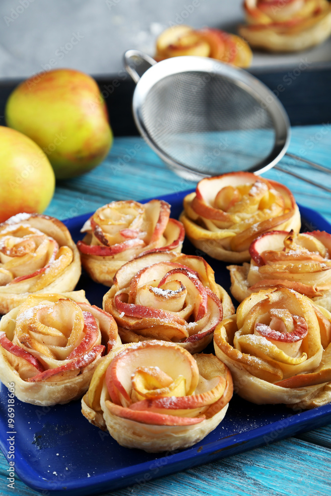 Fresh puff pastry with apple shaped roses on blue wooden table Fresh puff pastry with apple shaped roses on blue wooden table