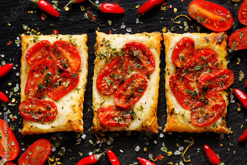 Foto Mini tomato tarts with addition of aromatic herbs on dark background