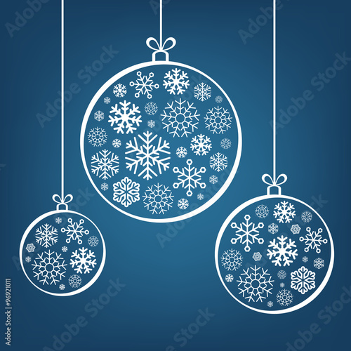 Hanging Christmas balls from snowflakes and ribbon on blue