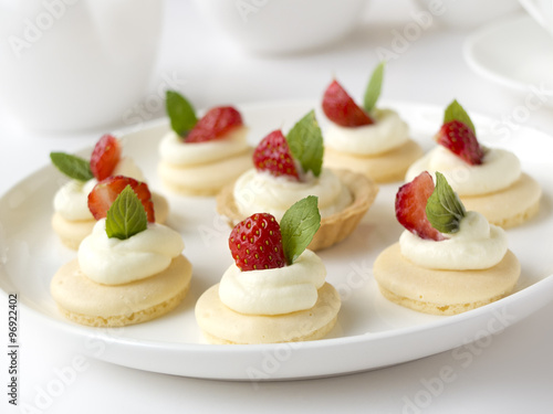 Many cakes or mini tart with fresh fruits, whipped cream and mints