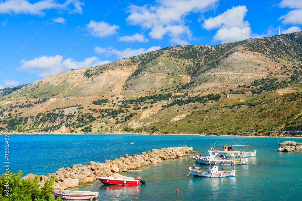Typical Greek fishing boats in sea bay against mountains in Zola port, Kefalonia island, Greece