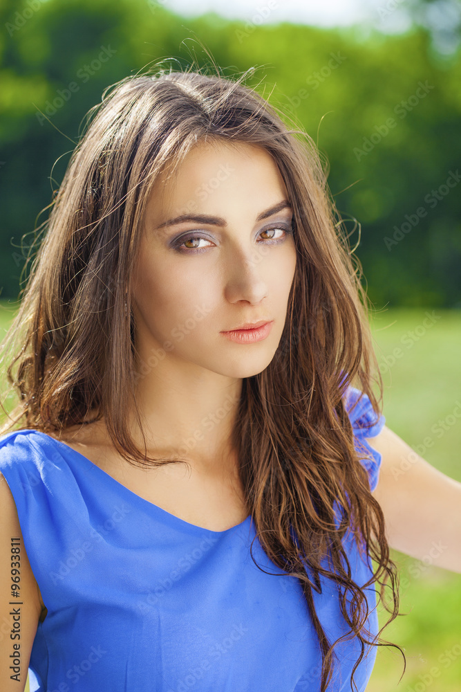 Naklejka premium Young brunette woman outdoors portrait