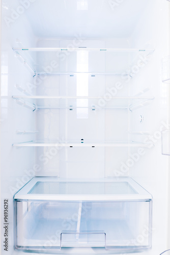 an open home based fridge with empty shelves closeup