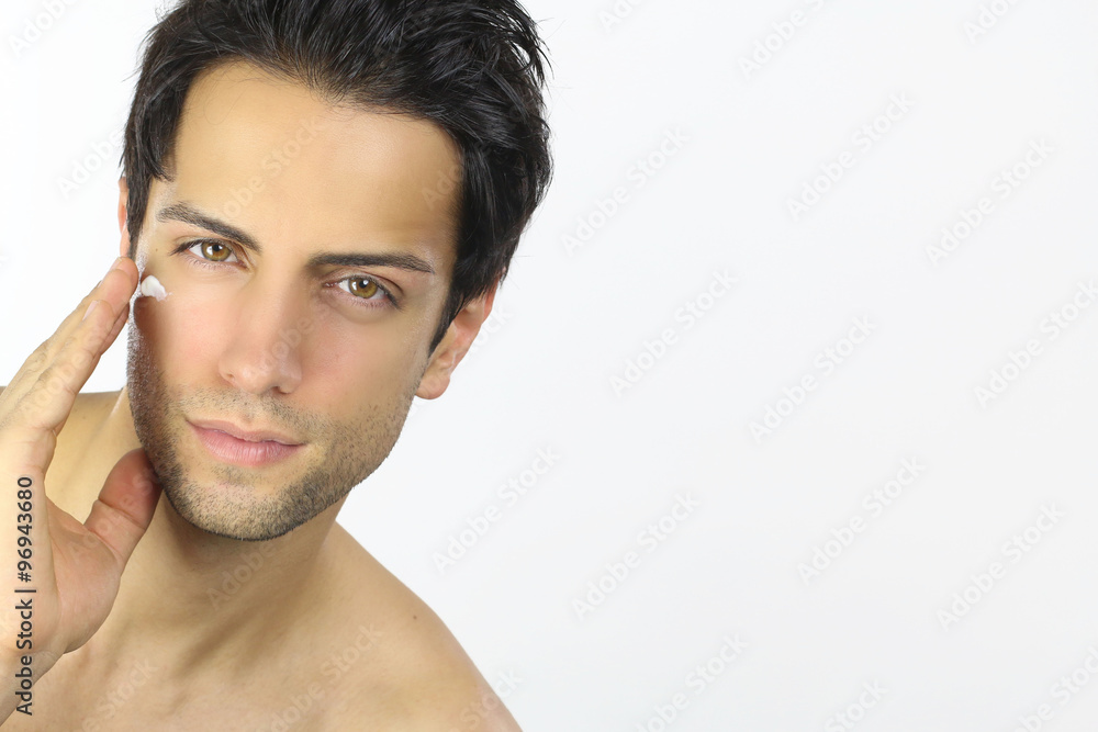 Handsome man applying cream on his face Handsome man applying cream on his face