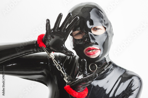 portrait of woman wearing latex clothes with handcuffs photo